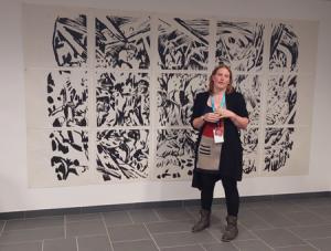 Louise Gros, commissaire de l’exposition « Morsure#4 » devant « Papier mineur » installation de « One Ink » d’après la gravure sur bois de Blandine Delvart et Johan Vaurs (Cl. Violaine Fayolle)